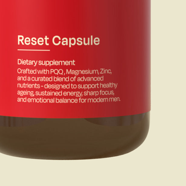 Red supplement bottle labeled 'Reset Capsule' with text about ingredients and benefits on a beige background.